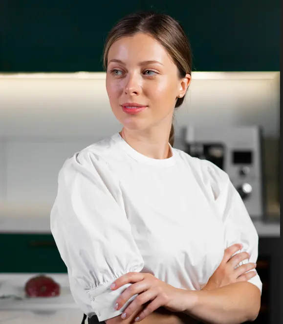 Portrait of Lila Monroe smiling in a cozy kitchen with cast iron skillet
