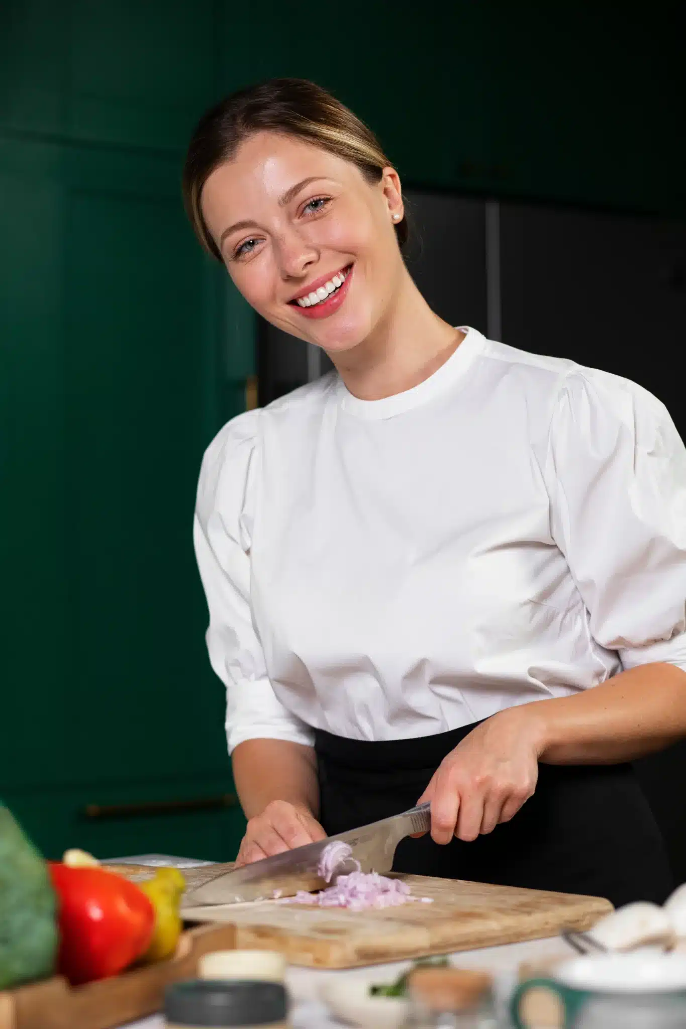 Smiling home cook Lila Monroe in a cozy kitchen holding a skillet with homemade comfort food