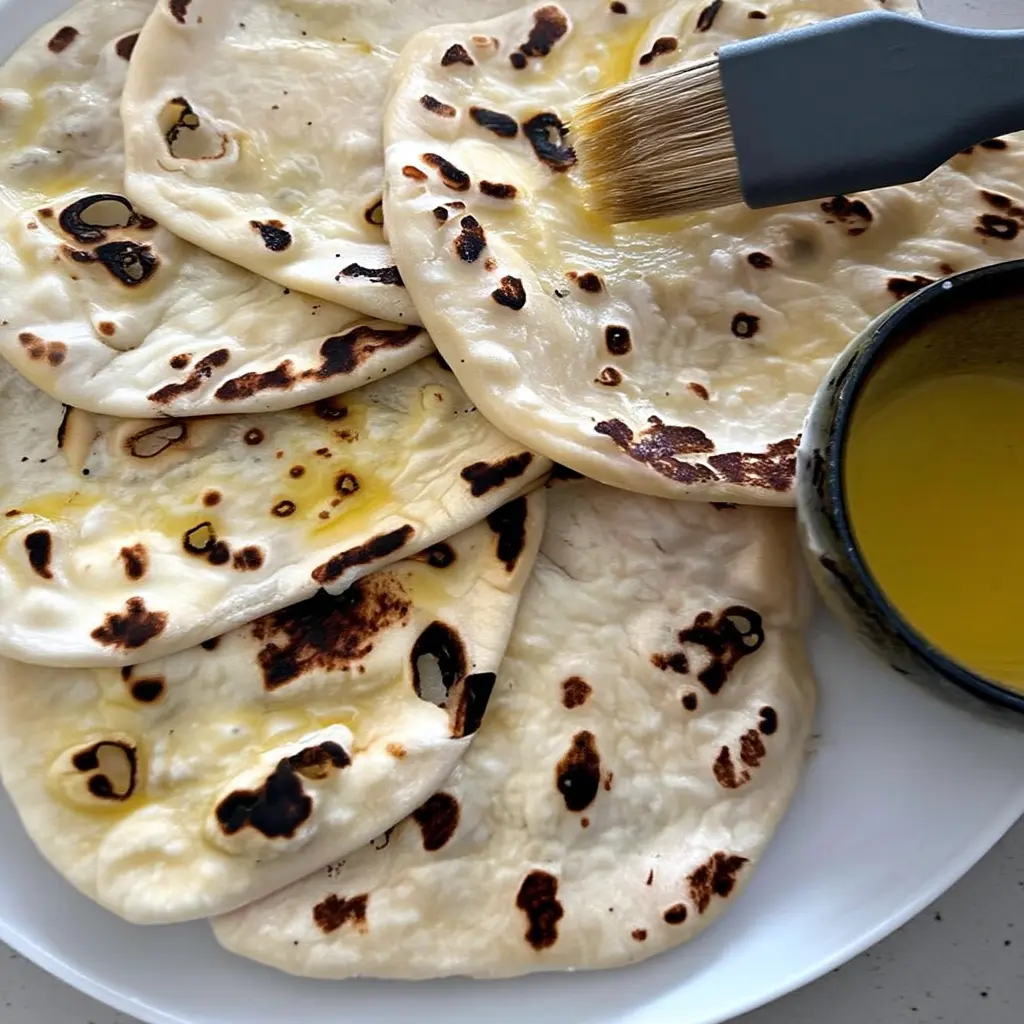 Sourdough Naan: The Softest Flatbread Recipe with Tangy Twist | DishRCP 9 Sourdough naan bubbling on hot cast iron pan
