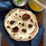 Sourdough Naan: The Softest Flatbread Recipe with Tangy Twist | DishRCP 7 Sourdough naan cooking in cast iron skillet with golden bubbles